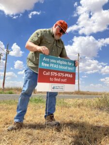 Man putting up a blood testing sign
