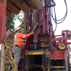 well driller inserting bit into well