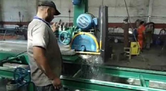 A worker cutting granite using a saw that applies water to the blade. The water reduces the amount of silica-containing dust that gets into the air.